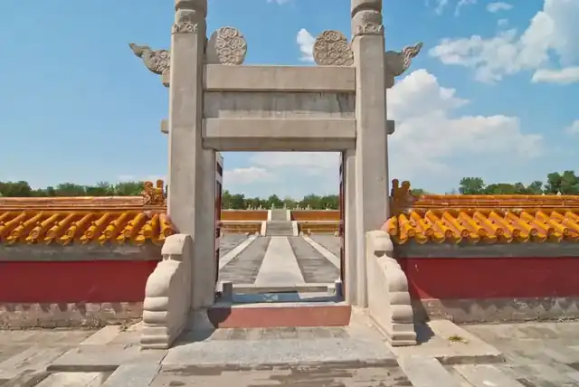 汉白玉棂星门正对方泽坛石阶，画面同时框出黄琉璃坛墙顶：方坛与黄瓦两个核心要素同框